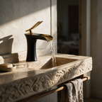 Black waterfall basin mixer with a gold lever and gold flared spout on a travertine vanity