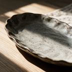 Macro detail of the irregular rim where the speckled glaze thins over the edge.