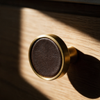 Macro view of the seam where the leather disc meets the brass surround.