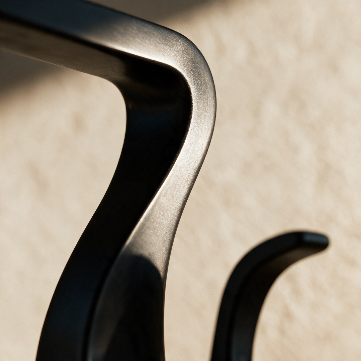 Macro close-up of the tight bend in the flat matte black ribbon body.