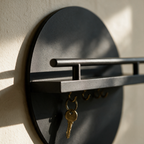 Close view of the shelf meeting the round disc with a brass key hanging from a hook below.