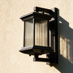 Thornbury outdoor lantern on a render wall in raking sunlight