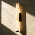 Marlow alabaster column wall sconce on textured plaster in afternoon light