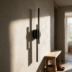 Juniper sconce unlit on a plaster hallway wall in afternoon light