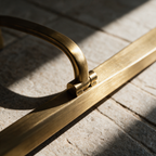 Close-up of the arched bracket meeting the brushed brass bar