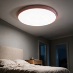 Slate disc lit above a bed in the evening