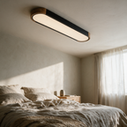 Tamar oval ceiling light seen end-on above a linen bed