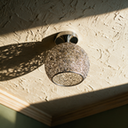 Wire nest ceiling light mounted flush against textured plaster
