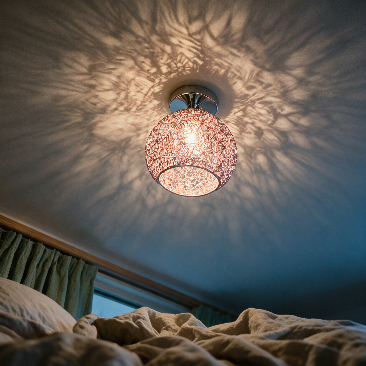 Wire nest ceiling light seen from below casting a tangled shadow