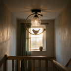 Side profile of the ceiling light backlit by a hallway window at golden hour with a timber stair rail in the foreground.