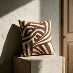 The geometric tufted cushion standing alone on a stone plinth against a plaster wall.