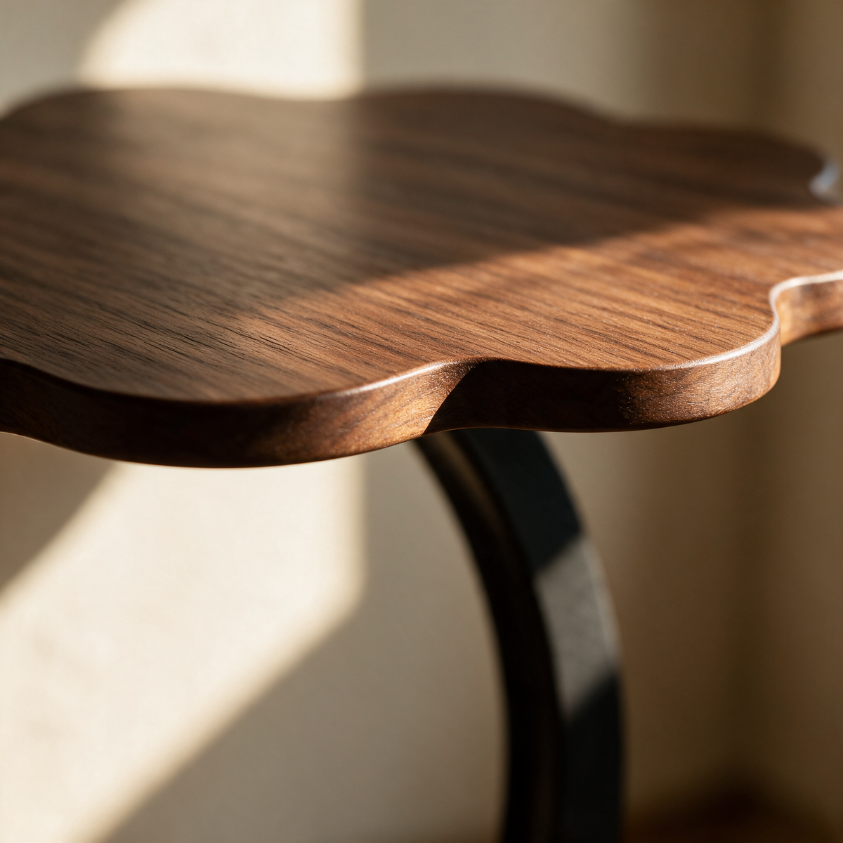 Close-up of two rounded lobes of the scalloped dark wood top