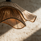 Macro close-up of the ruffled jute rim showing the coarse woven fibres and folds with warm light behind.