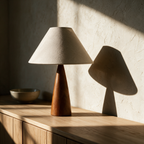 Unlit linen cone lamp on a pale oak sideboard in raking afternoon light.