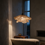 Side profile of the double-tier frilled jute pendant lit in a tall living room at dusk.