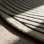 Macro detail of the edge of a black arc meeting the cream tufted pile near the bound rim.