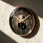 The clock alone on a textured plaster wall with raking light on the rose-gold rim
