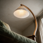 Looking up from a reading chair at the glowing pleated cone and the curving arc.