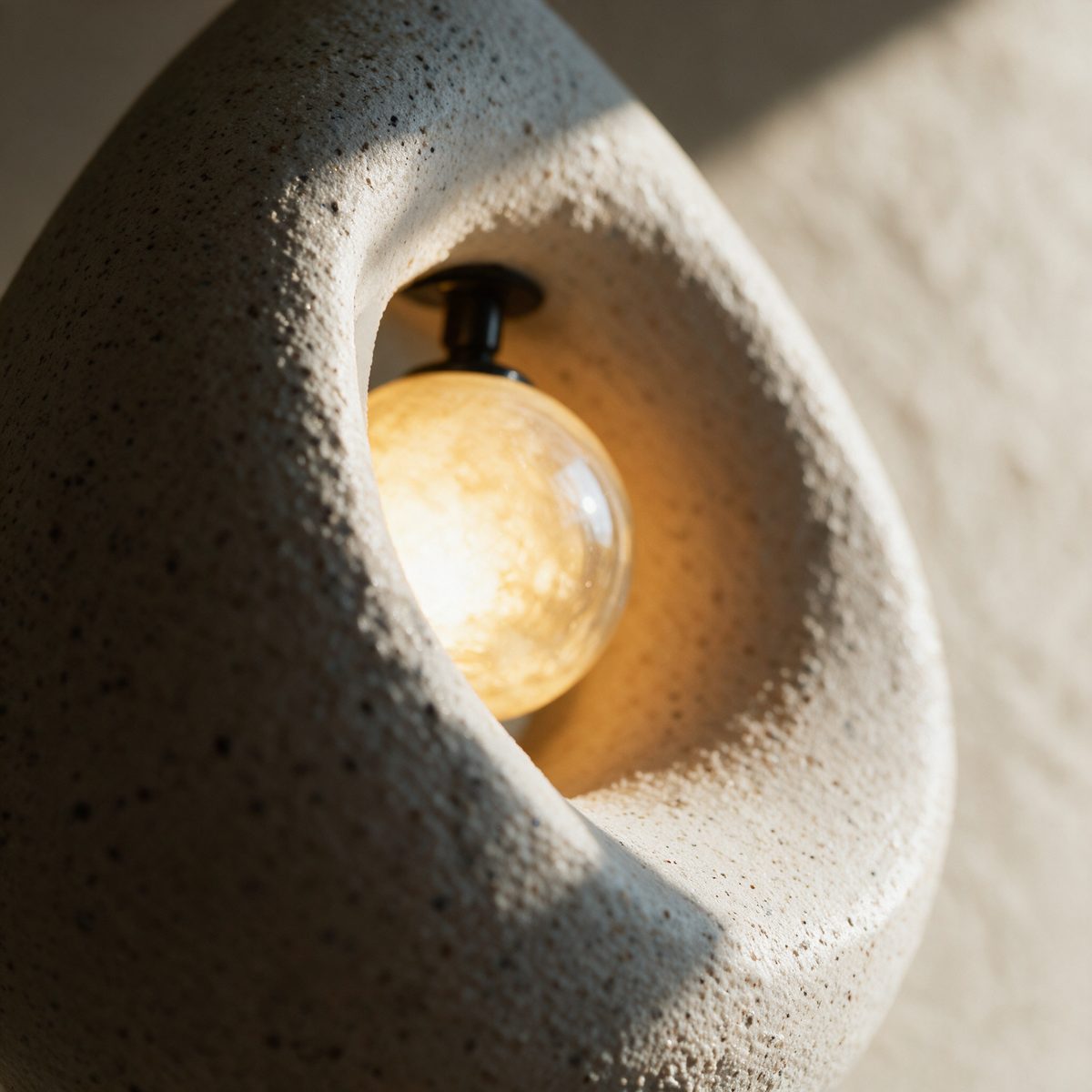 Macro close-up of the speckled resin rim meeting the smooth glowing glass globe inside the hollow.
