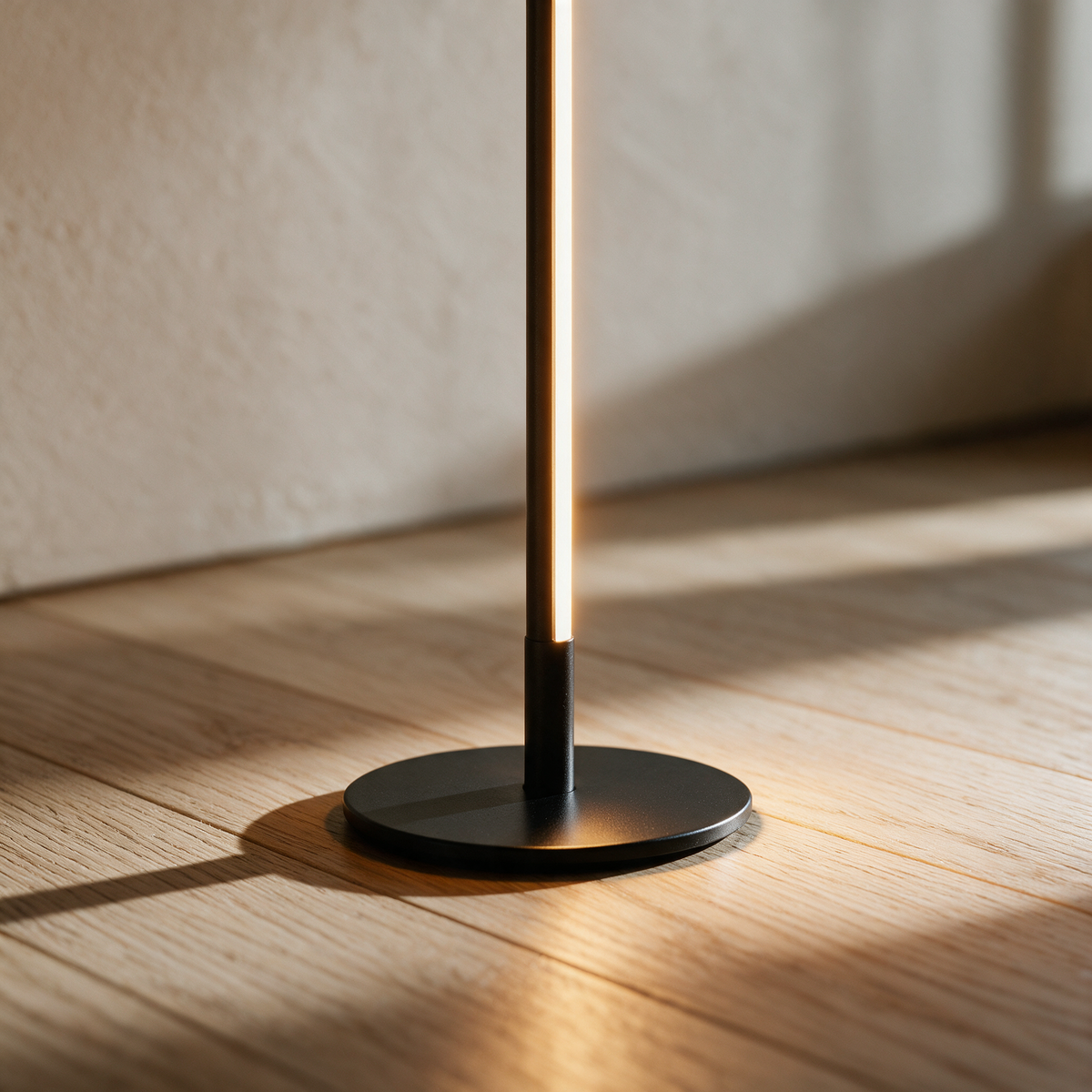 Close-up of the small round base where the thin rod meets the oak floor.