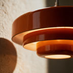 Macro close-up of three stacked lacquered tiers with warm light escaping between the discs.
