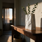 Low view of the vase with eucalyptus on a hallway console at golden hour