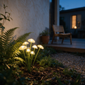 Cluster of solar mushroom lights glowing amber among ferns at dusk.