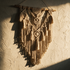 The hanging alone on a textured plaster wall with raking light through the knotwork
