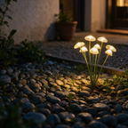 Ground-level night view of the lit mushroom cluster among pebbles.