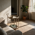 Two-tier rolling side table beside a linen sofa holding a cup and a book.